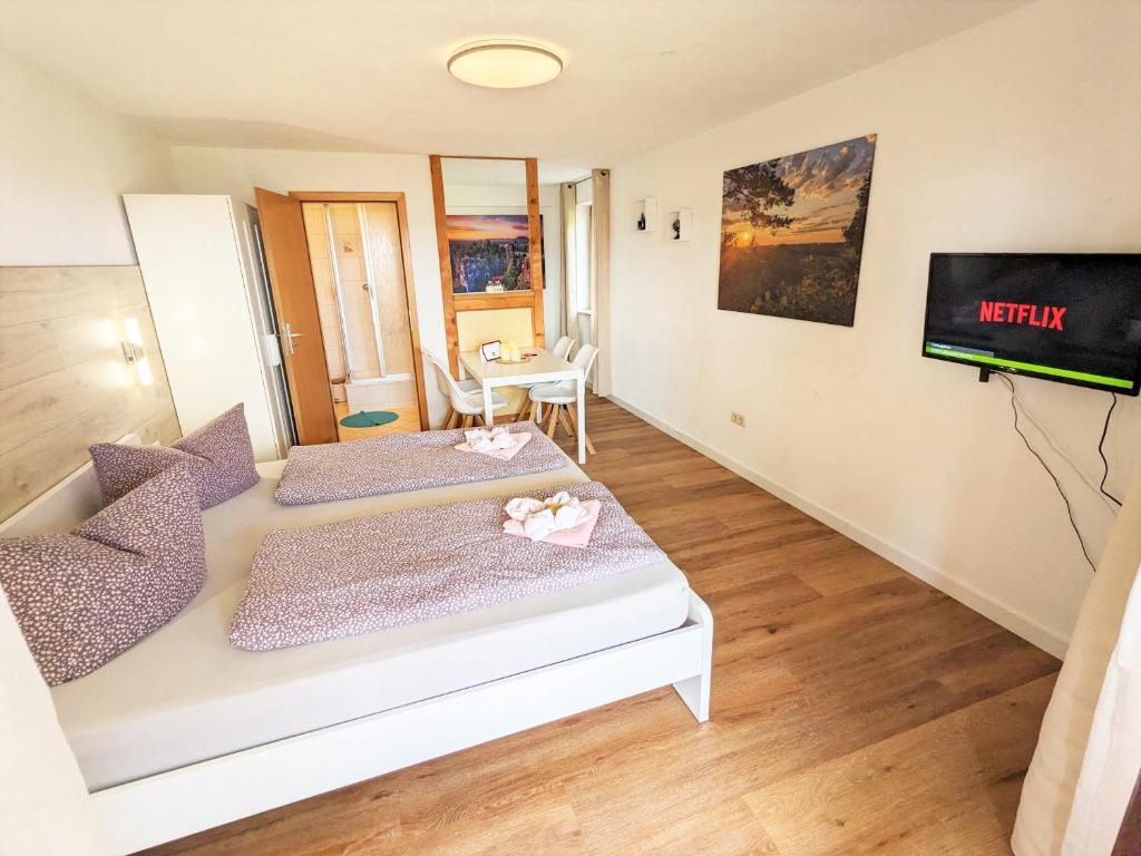 une chambre avec deux lits et une télévision au mur dans l'établissement S2 - Urlaubsmagie - Am Wanderweg mit Terrasse, à Sebnitz