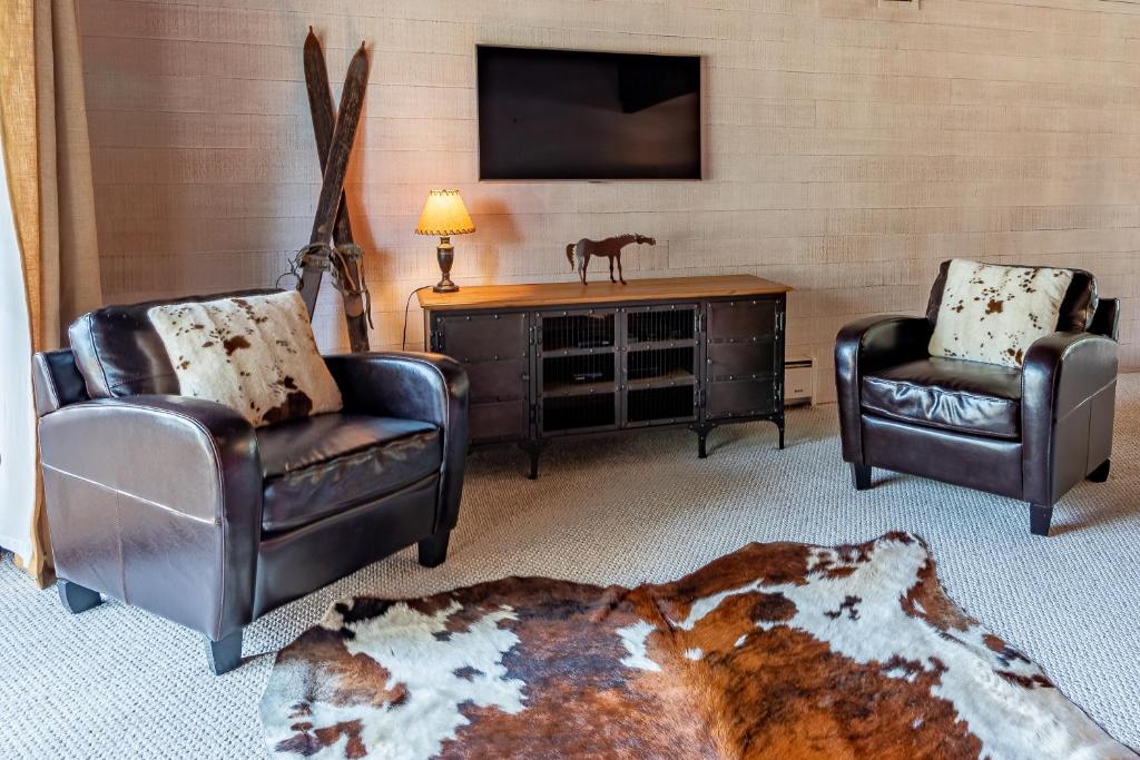 a living room with two chairs and a flat screen tv at Snowcreek Condo 1579 -Sun Valley Resort Amenities Plus Hot Tub Onsite in Sun Valley