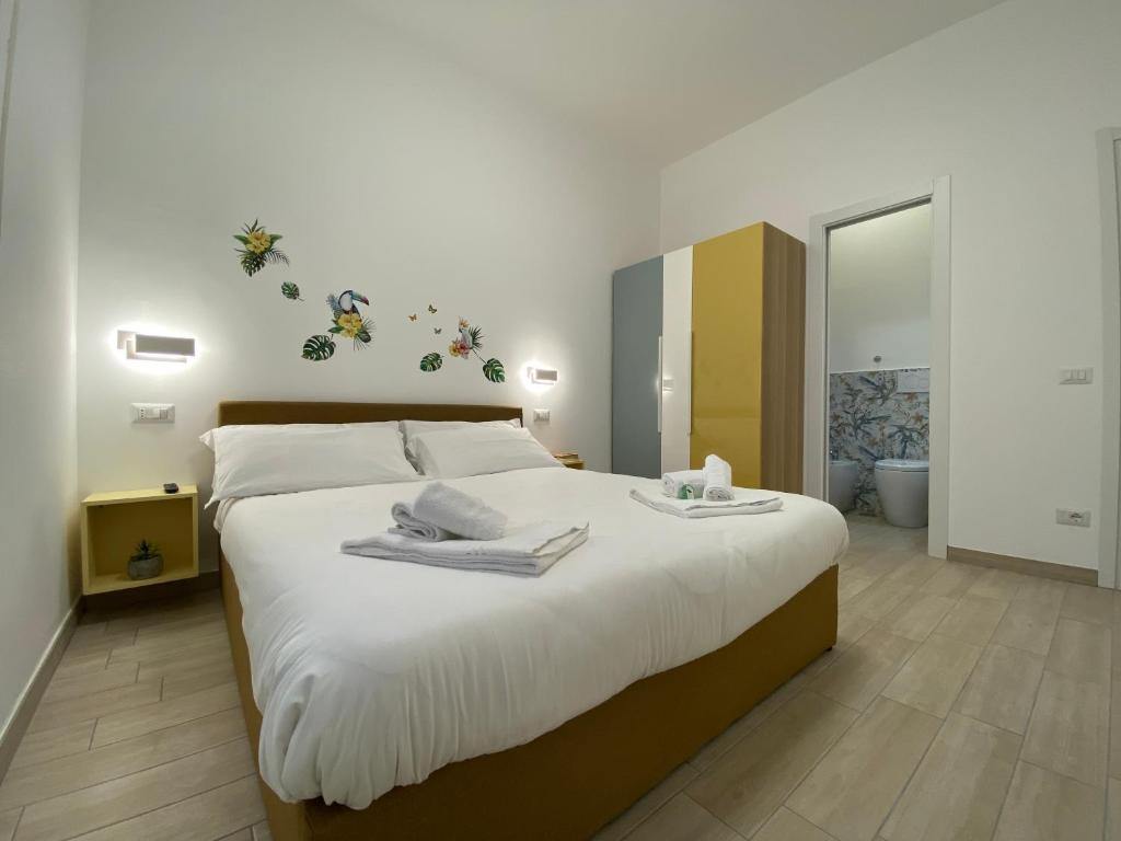 a bedroom with a large bed with towels on it at Le casette di Frà Host and Go in Santa Severa