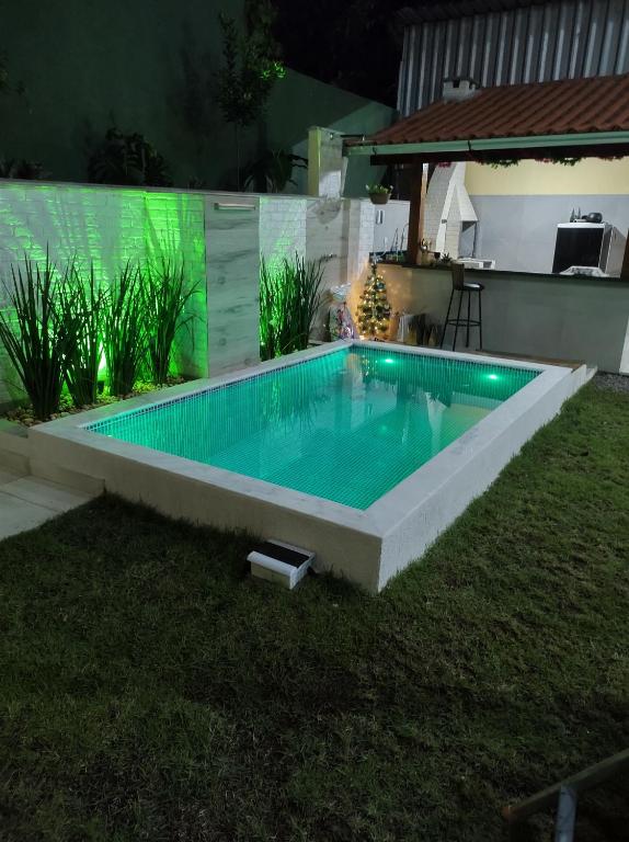 a swimming pool in a backyard at night at Espaço Zoey in Búzios