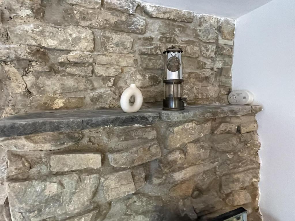 a stone wall with a candle on a ledge at Charming 1-Bed Cottage in Brynmenyn in Bridgend