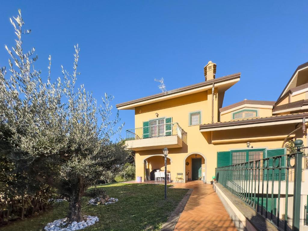 格羅塔費拉塔的住宿－La casetta del Tuscolo -Secret rooms-，院子里有树的黄色大房子