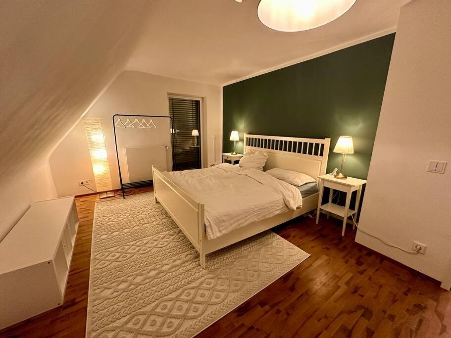 sypialnia z białym łóżkiem i zieloną ścianą w obiekcie 77m² - 3 Zi Modern Zentrum Küche Dachterrasse WLAN w mieście Karlsruhe