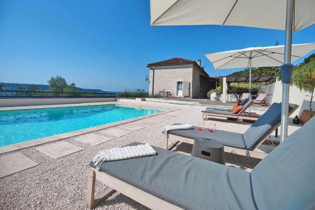 une villa avec une piscine, 2 chaises et un parasol dans l'établissement Domaine Lapèze, Gite Le Cabernet., à Montcuq