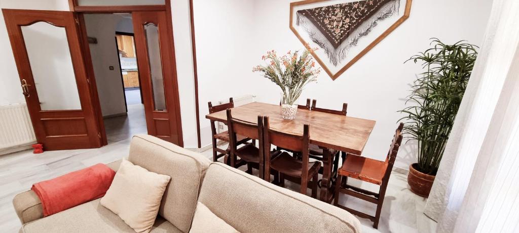 a dining room with a table and a couch at Vivienda con fines turísticos "Casa Paquita" in Andújar