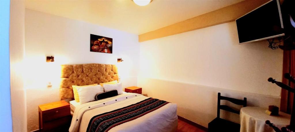Habitación de hotel con cama y TV en Andean Riverside, en Ollantaytambo