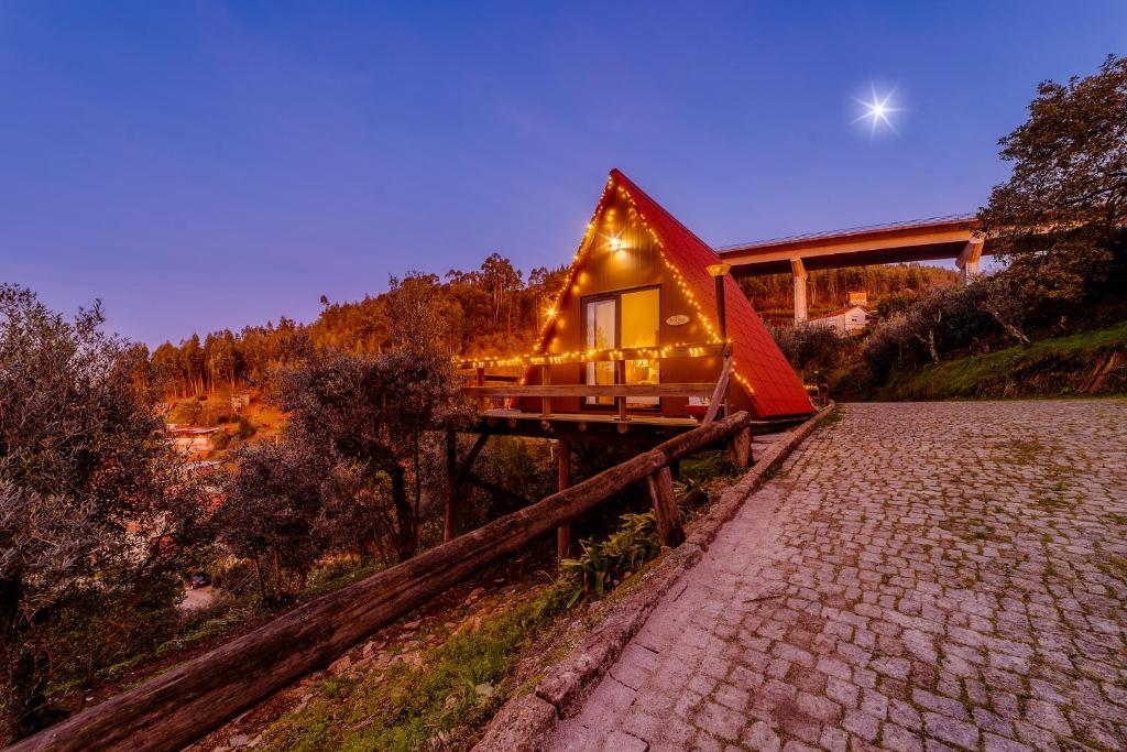 una casa su un ponte con luci sopra di Arrabia Guest Houses Glamping a Raiva