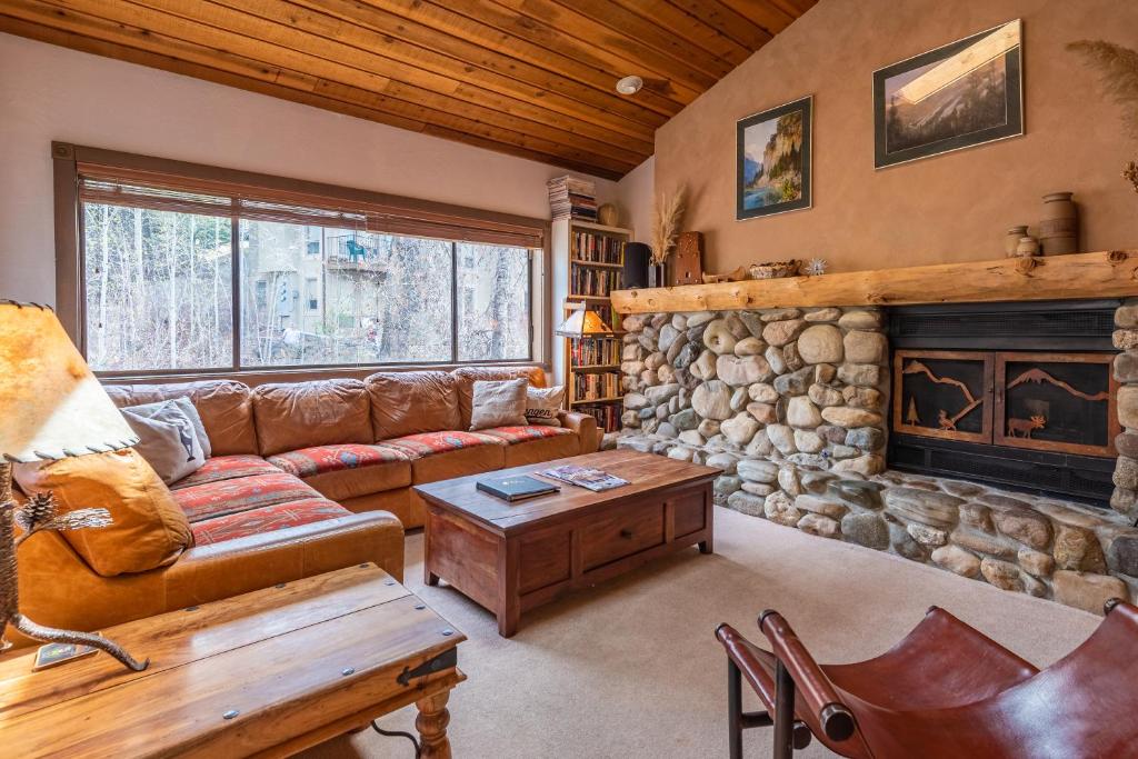 a living room with a couch and a fireplace at Bridgepoint Condo 24 - On Trail Creek & Walk to Downtown and Bald Mt in Ketchum
