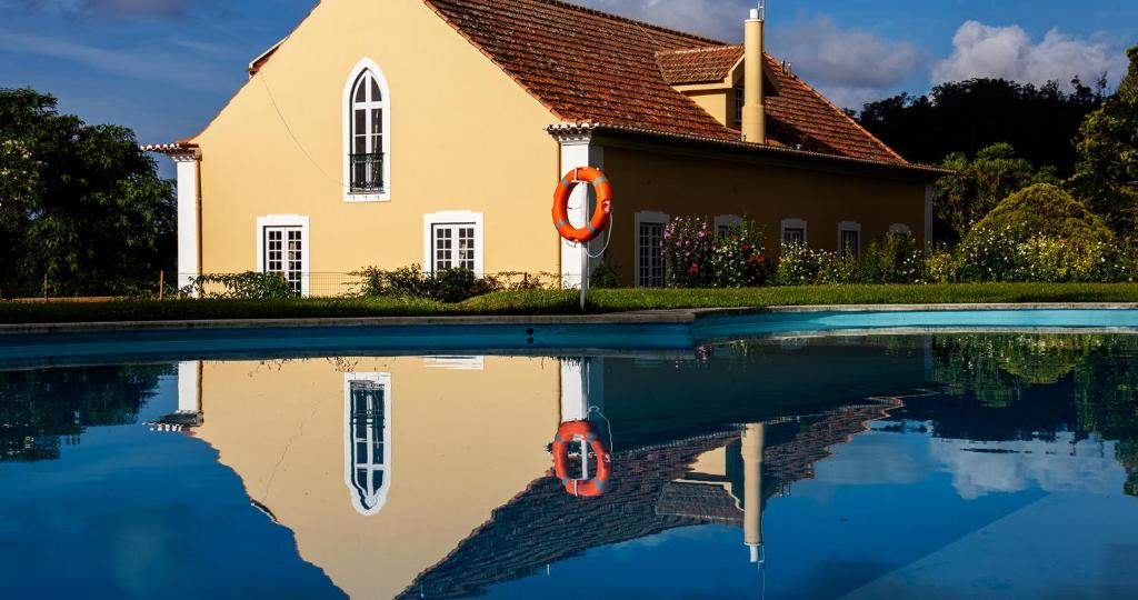 a church with its reflection in a swimming pool at Quinta da Nasce Água in Angra do Heroísmo