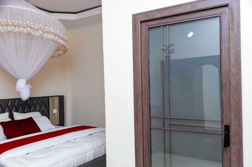 a bedroom with a bed and a glass door at KIGALI GREET HOTEL in Kigali