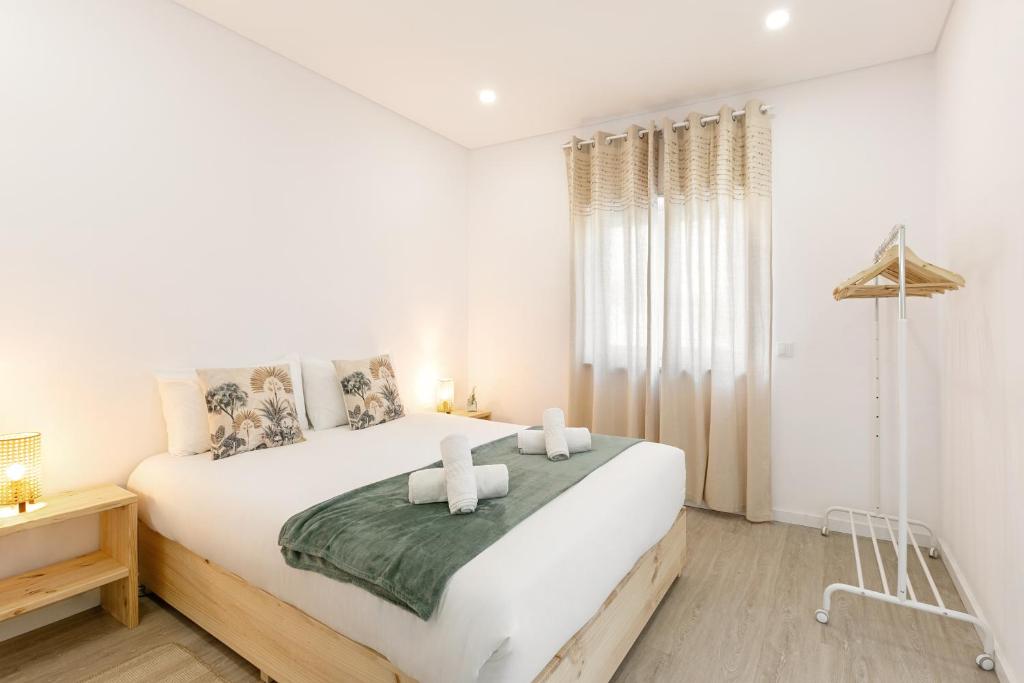 una camera da letto bianca con un letto grande con due asciugamani di Casa da Manuela ad Atouguia da Baleia