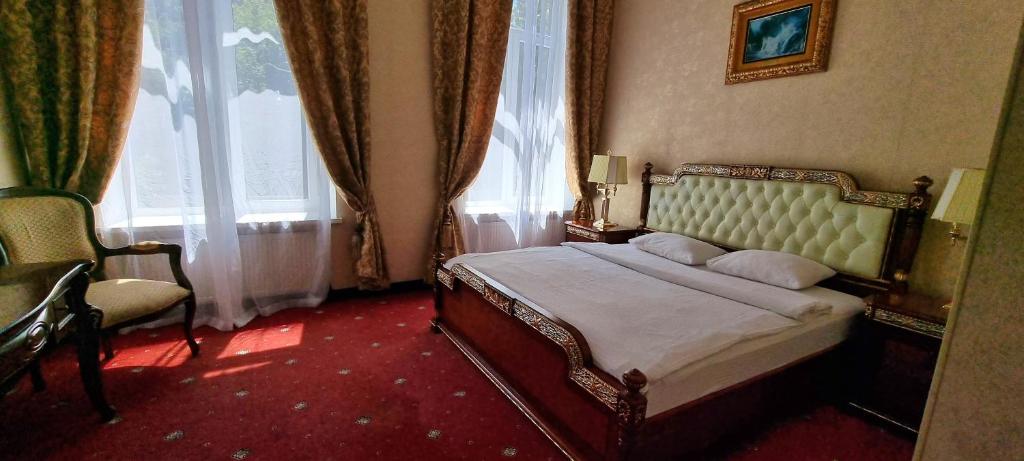 una camera con un letto e una sedia e una finestra di Oreanda Hotel a Odessa
