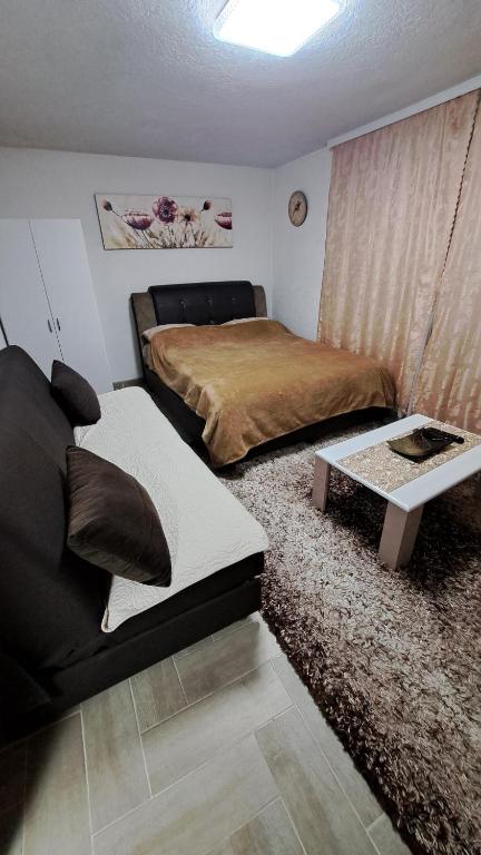 a bedroom with a bed and a couch and a table at Konak in Novi Pazar