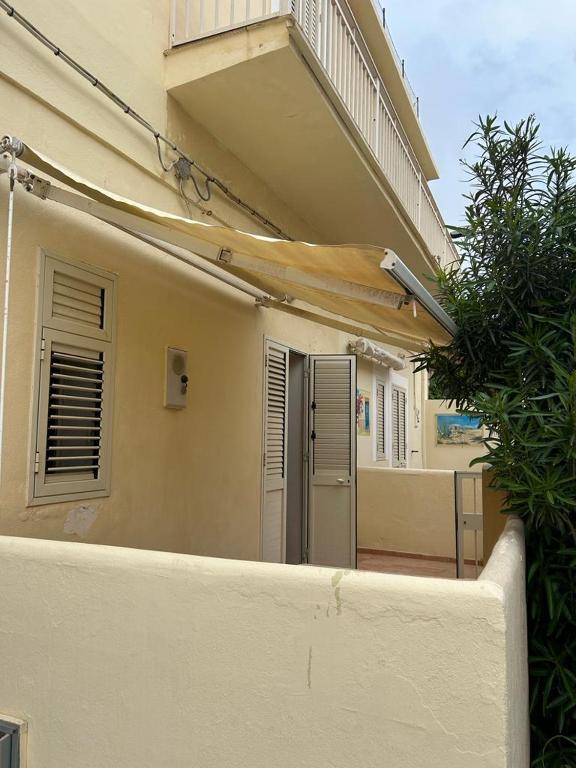 Edificio blanco con balcón y puerta en Casa indipendente Leo Mar, en Lampedusa