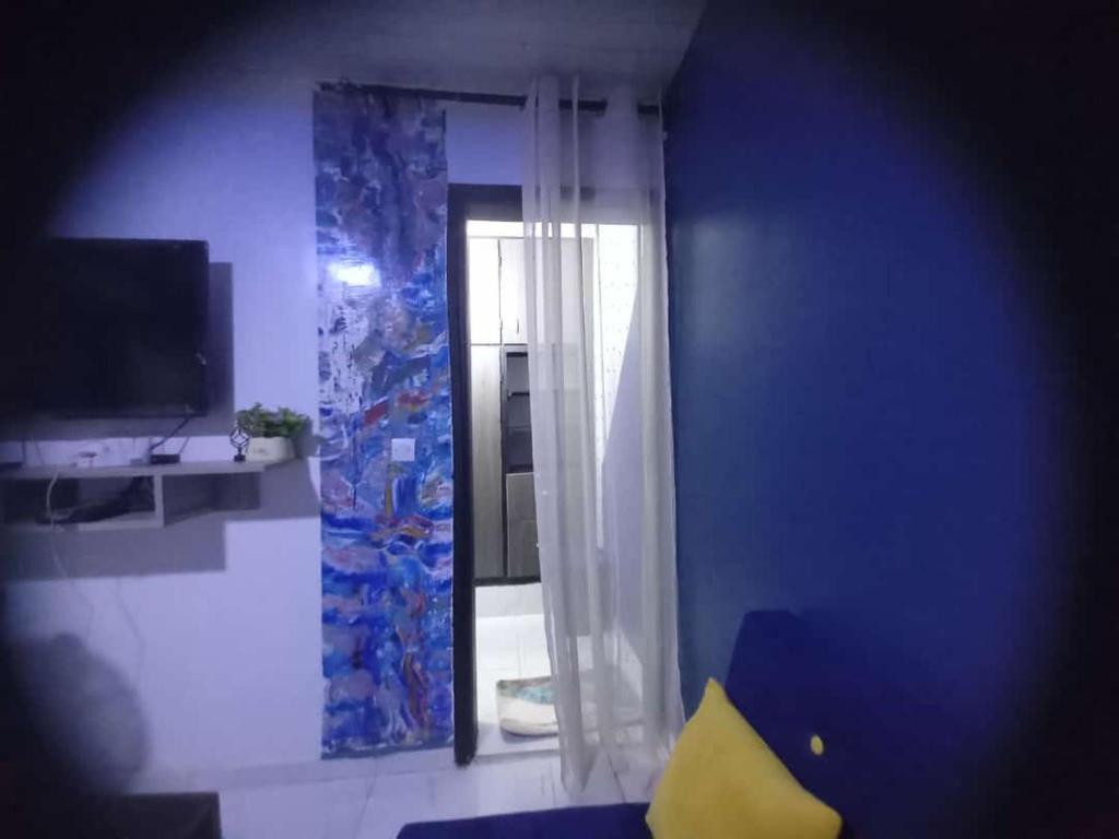 un salon avec un mur bleu et une fenêtre dans l'établissement Impeccable 1-Bed Apartment, 