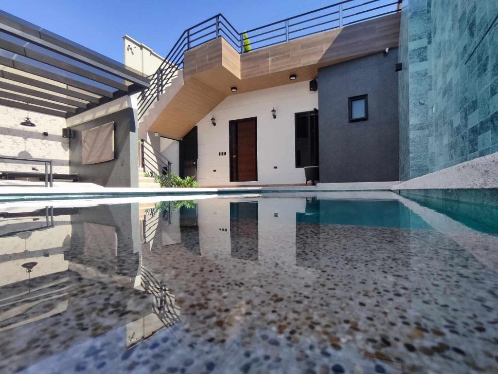 een huis met een zwembad ervoor bij GZ GUEST HOUSE in Cuenca