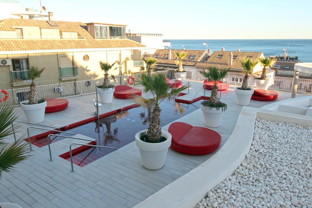patio z czerwonymi ławkami, palmami i oceanem w obiekcie Sea View Apartment Near The Beach w mieście Fuengirola