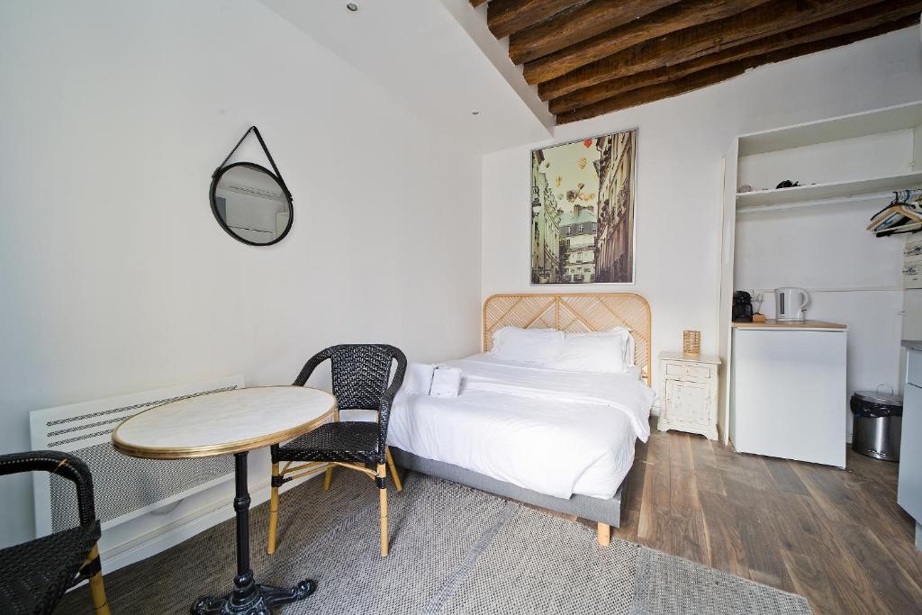une chambre avec un lit, un bureau et une table dans l'établissement Clery 31, à Paris