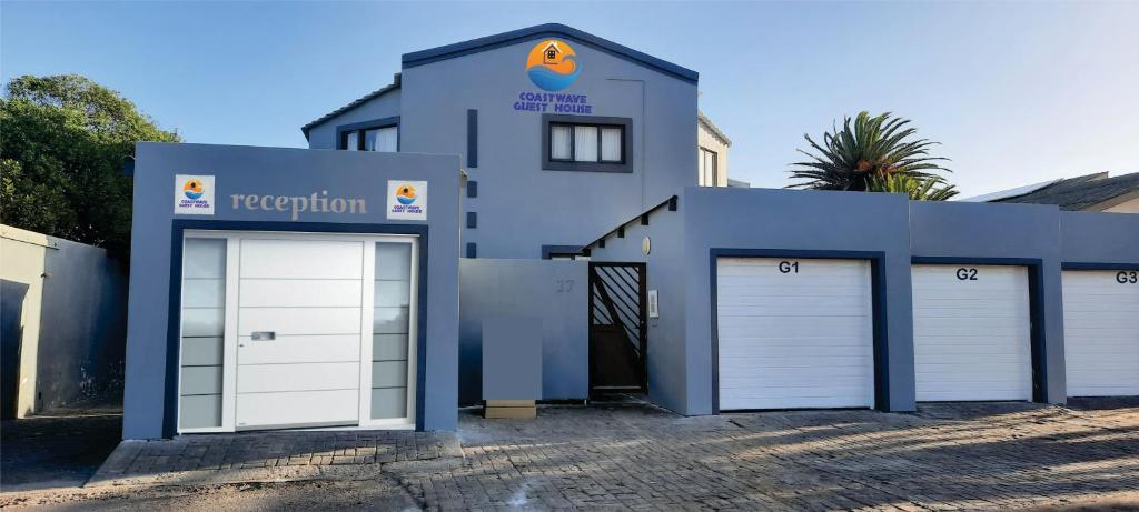 a blue building with two white garage doors at Coastwave Guest House in Walvis Bay
