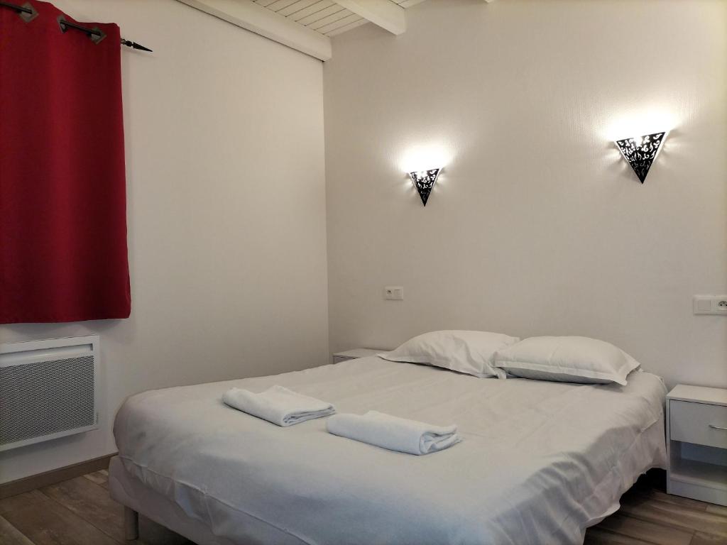 1 dormitorio con 1 cama con 2 toallas en Appart'Hôtel Les ACACIAS courte et longue durée, en Bischoffsheim