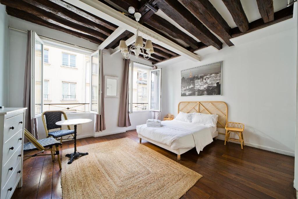 une chambre avec un lit, une table et des chaises dans l'établissement Cléry 45, à Paris