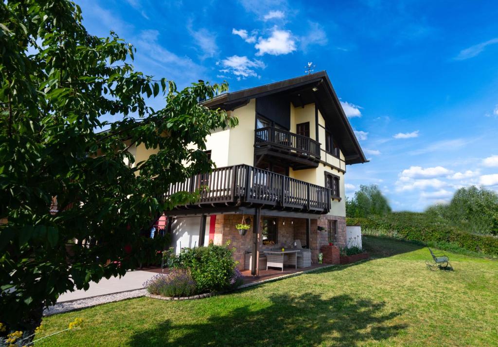 ein Haus mit einem Balkon und einem Hof in der Unterkunft Sonnige Aussicht in Waldhölzbach