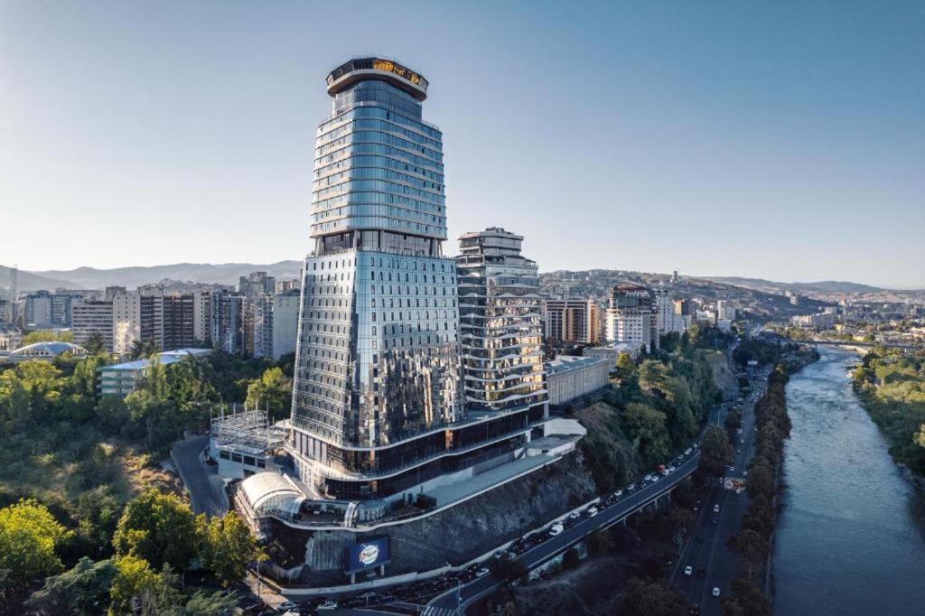 an aerial view of a tall building next to a river at King david royal Dan floor 21 in Tbilisi City