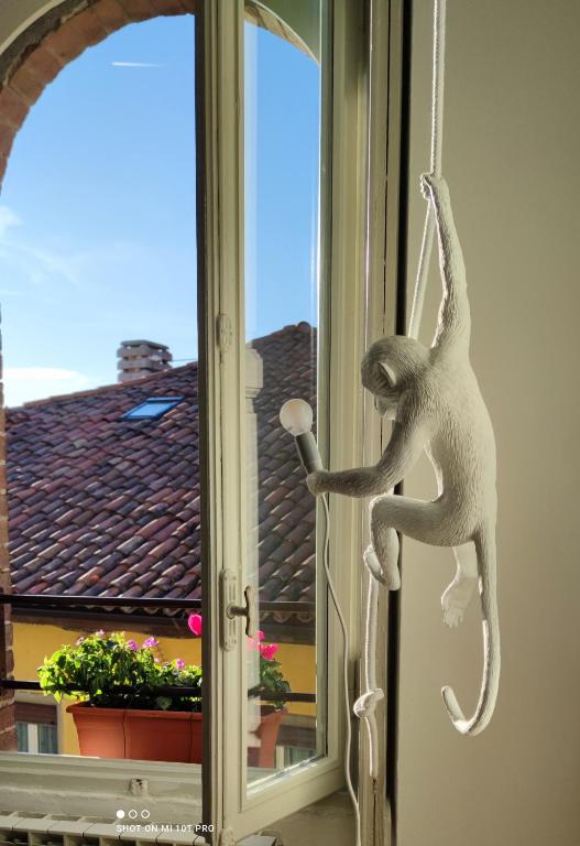 um macaco de brinquedo pendurado numa janela num quarto em B&B Al 27 em Paderno dʼAdda