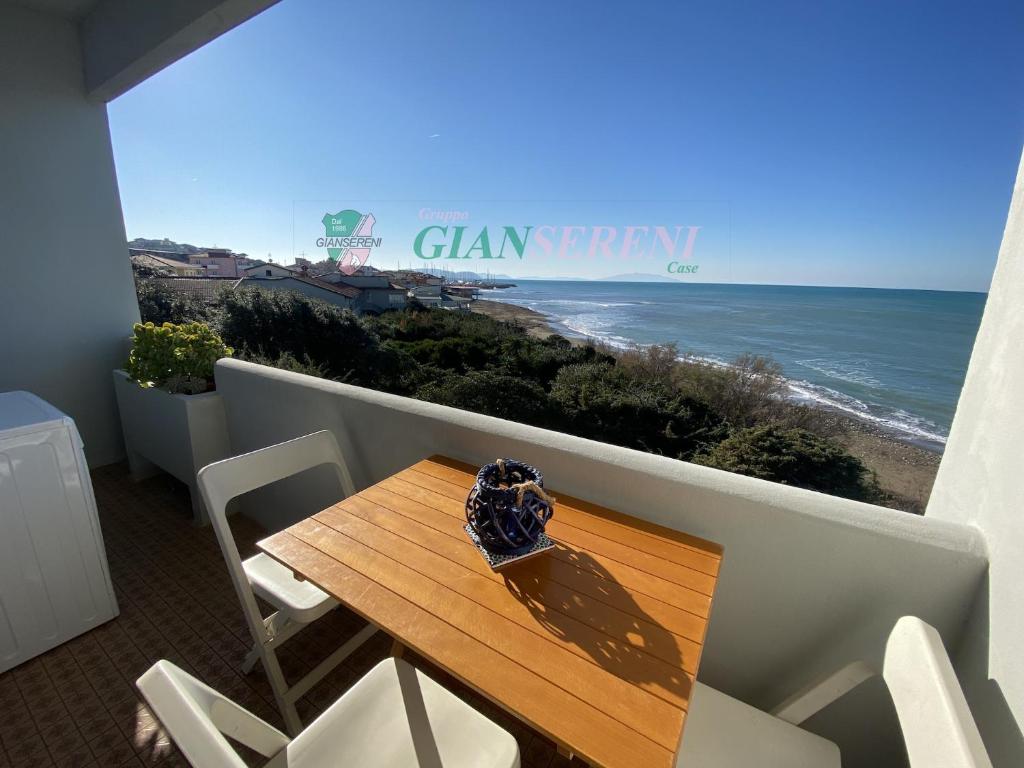 ein Tisch und Stühle auf einem Balkon mit Blick auf das Meer in der Unterkunft CONCHIGLIA in San Vincenzo
