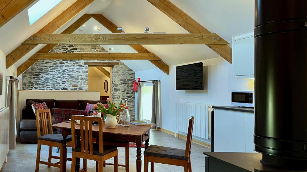 a kitchen and a dining room with a table and chairs at Charming Countryside Barn in Pencader