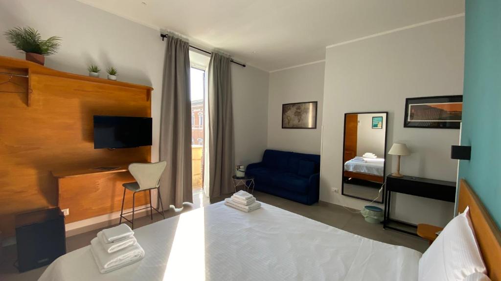 um quarto com uma cama e um sofá azul em Cecilia B&B Rome em Roma