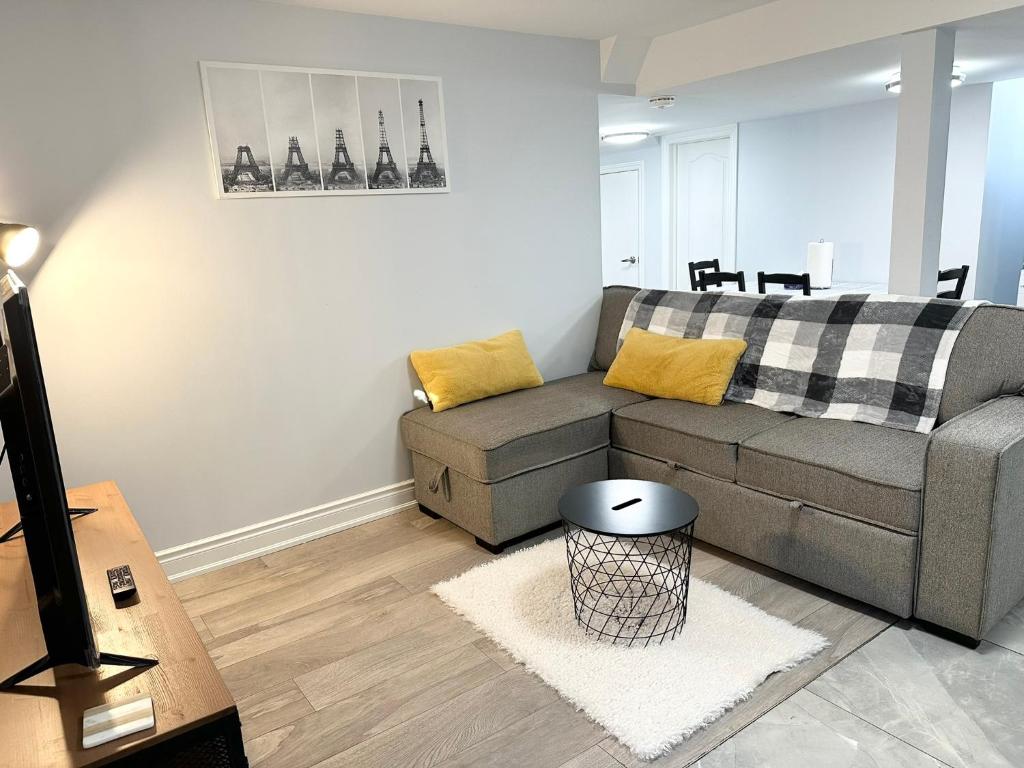 a living room with a couch and a table at Cozy & Comfortable basement apartment in Mississauga