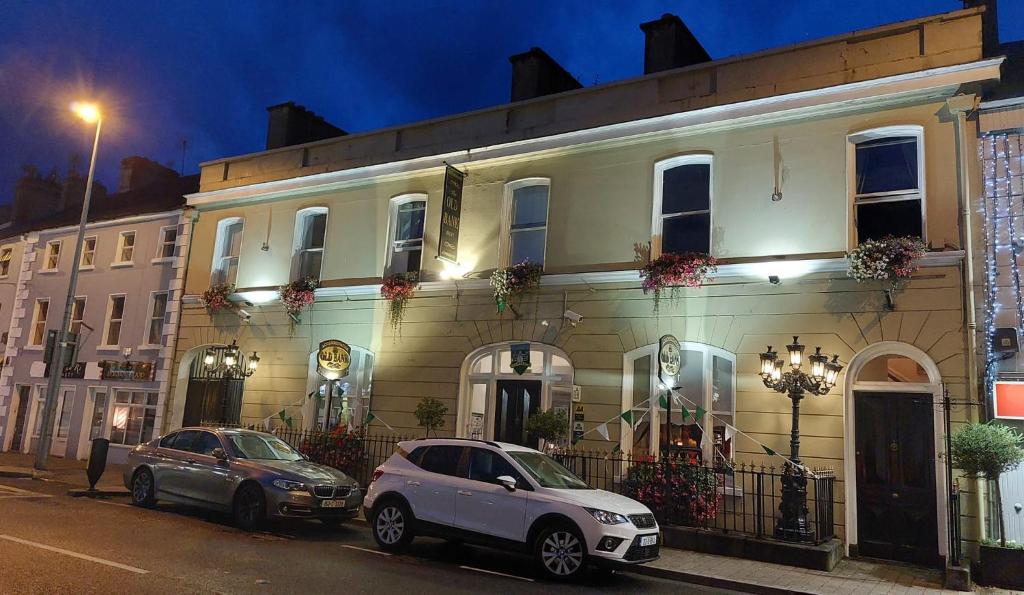 dois carros estacionados em frente a um edifício à noite em The Old Bank Bruff Townhouse em Bruff