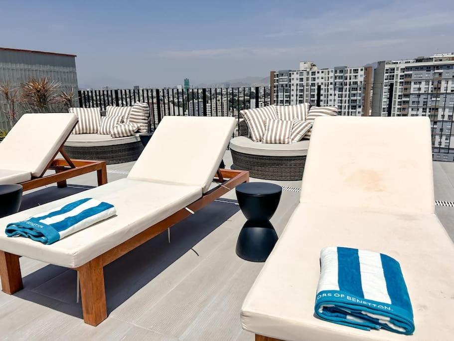 three lounge chairs on a roof with a view at Bellísimo departamento de estreno en Barranco in Lima