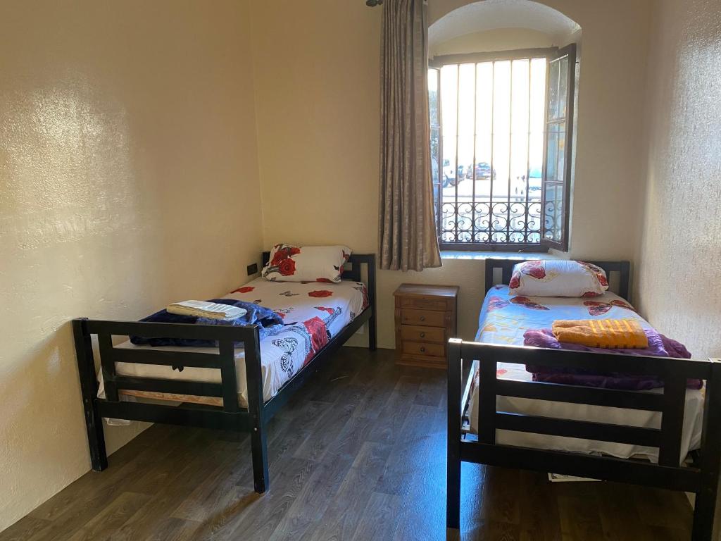 2 camas individuais num quarto com uma janela em Private room in the kasbah em Tânger
