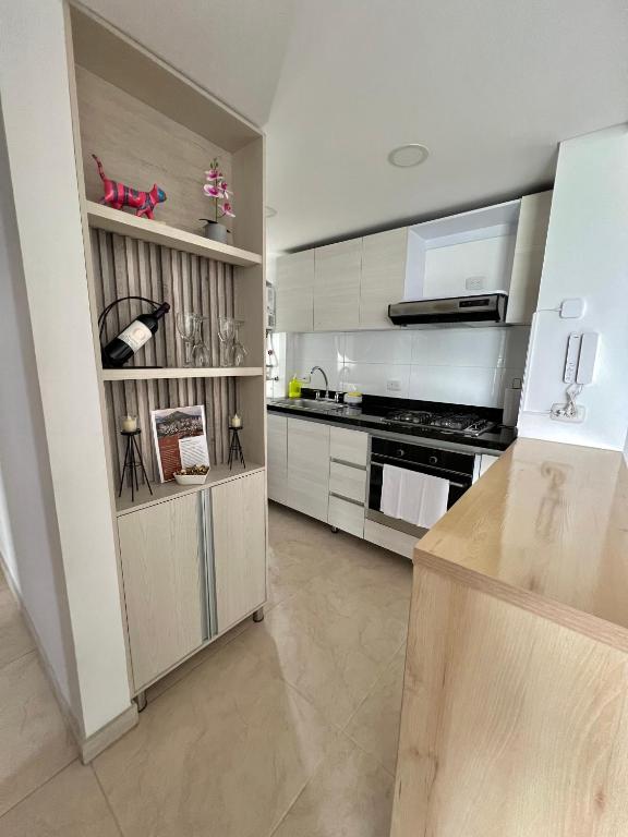 eine Küche mit weißen Schränken und einem Herd in der Unterkunft Lindo y cómodo apartamento 804 in Cali