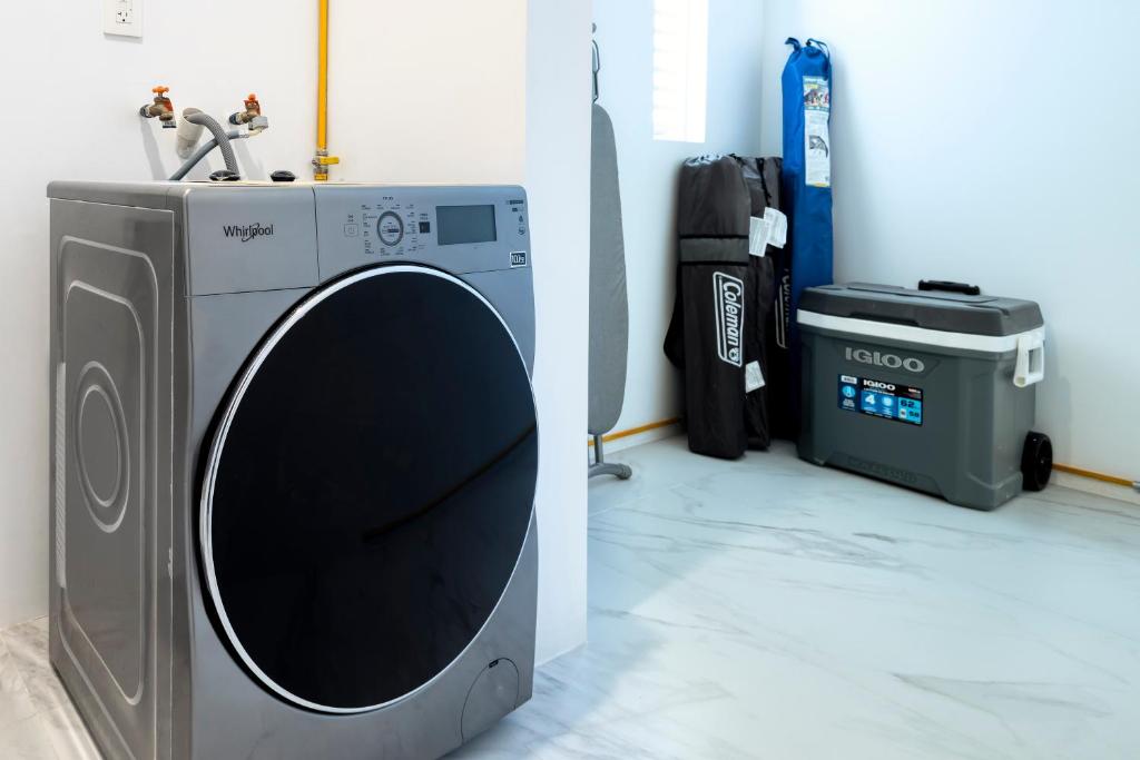 a washing machine in a room next to a trash can at Lumina at Marea Cabo San Lucas in Cabo San Lucas