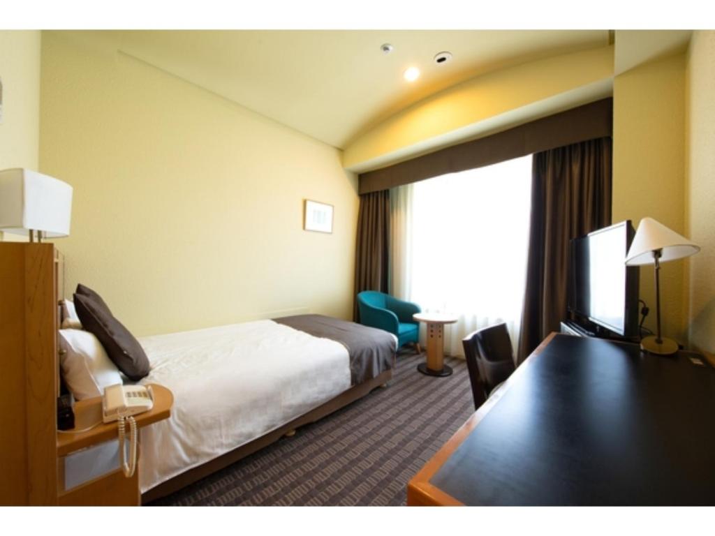 een hotelkamer met een bed en een televisie bij Hotel Nagoya Garden Palace - Vacation STAY 25765v in Nagoya