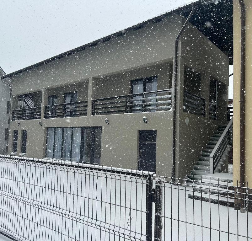 ein Gebäude mit Schnee, der davor fällt in der Unterkunft Casa Matteo in Moisei