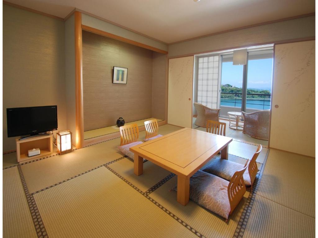 a living room with a table and a television at Hotel Alegria Gardens Amakusa - Vacation STAY 40453v in Amakusa