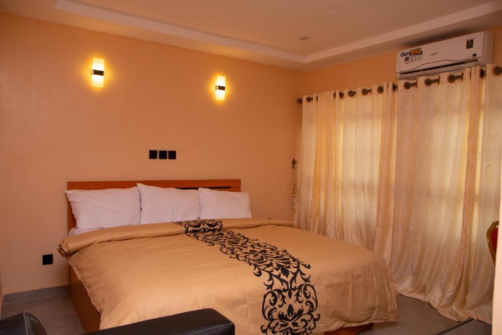 um quarto com uma cama com um cobertor preto e branco em Dopad Hills Hotel and Suites em Ojo