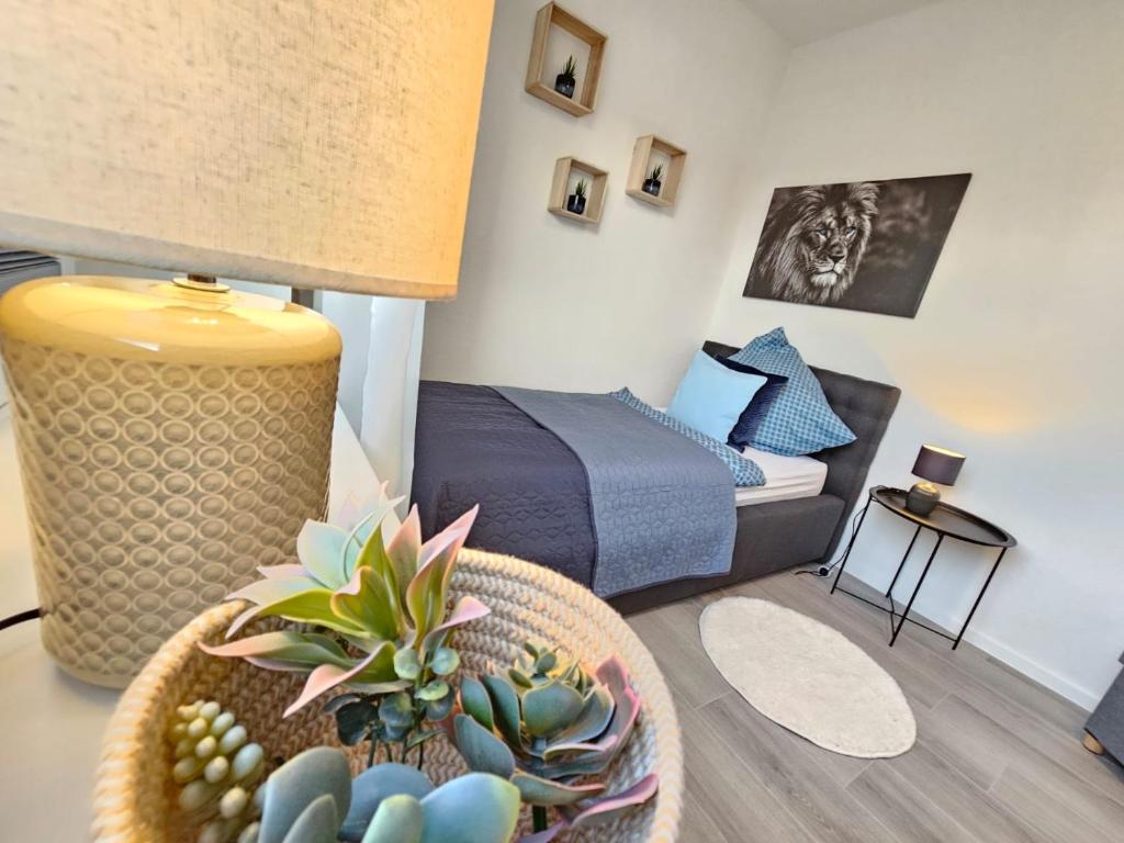 Cette chambre comprend un lit et une table avec des plantes. dans l'établissement Blu Apartment Ferienwohnung, Businesswohnung, Monteurzimmer, à Salzgitter