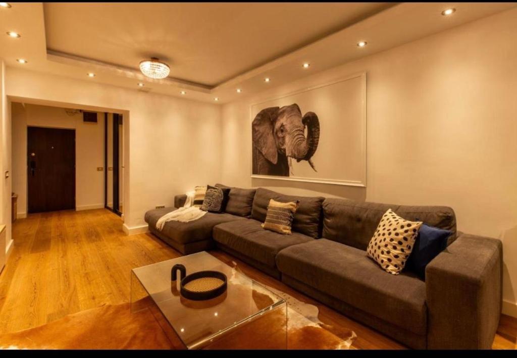 soggiorno con divano e dipinto con un elefante di Downtown Oasis Unirii Apartment a Bucarest