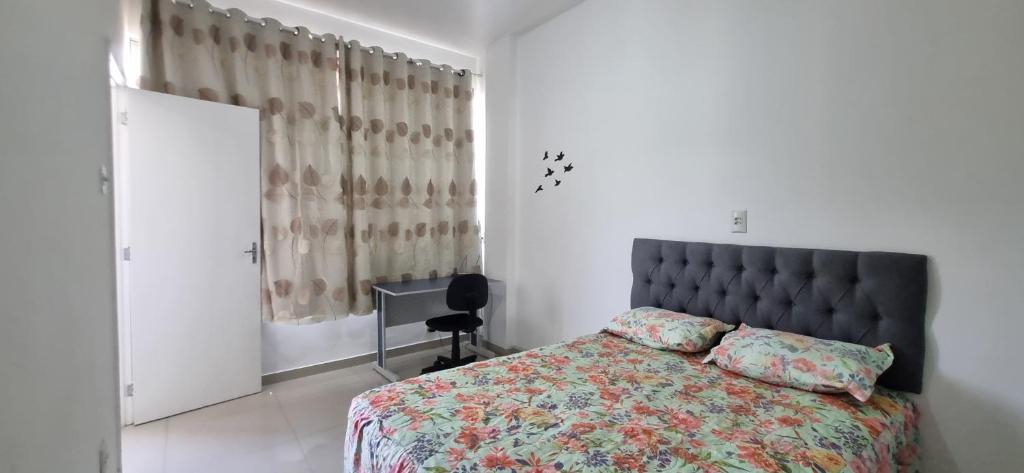 a bedroom with a bed and a desk and a window at Flat Reformado no centro histórico RJ in Rio de Janeiro