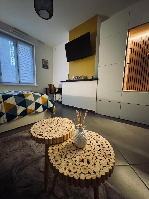 a living room with a table and a couch at Escapade - Studio cosy au centre de Saint-Omer in Saint-Omer