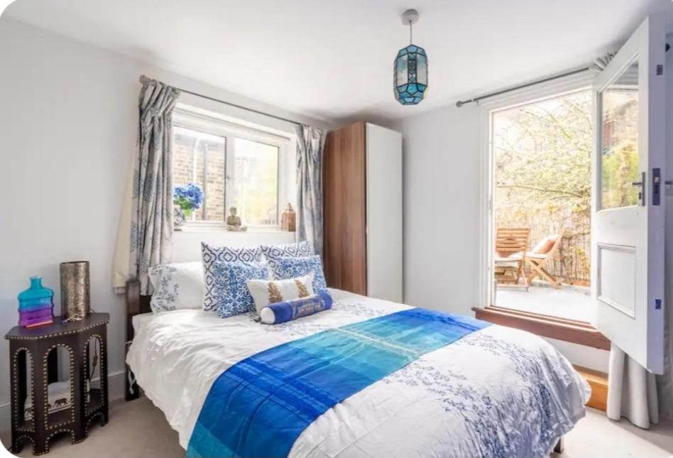 ロンドンにあるStylish room with private bath and terrace in centrally located Claphamのベッドルーム1室(青と白のシーツが敷かれたベッド1台、窓付)