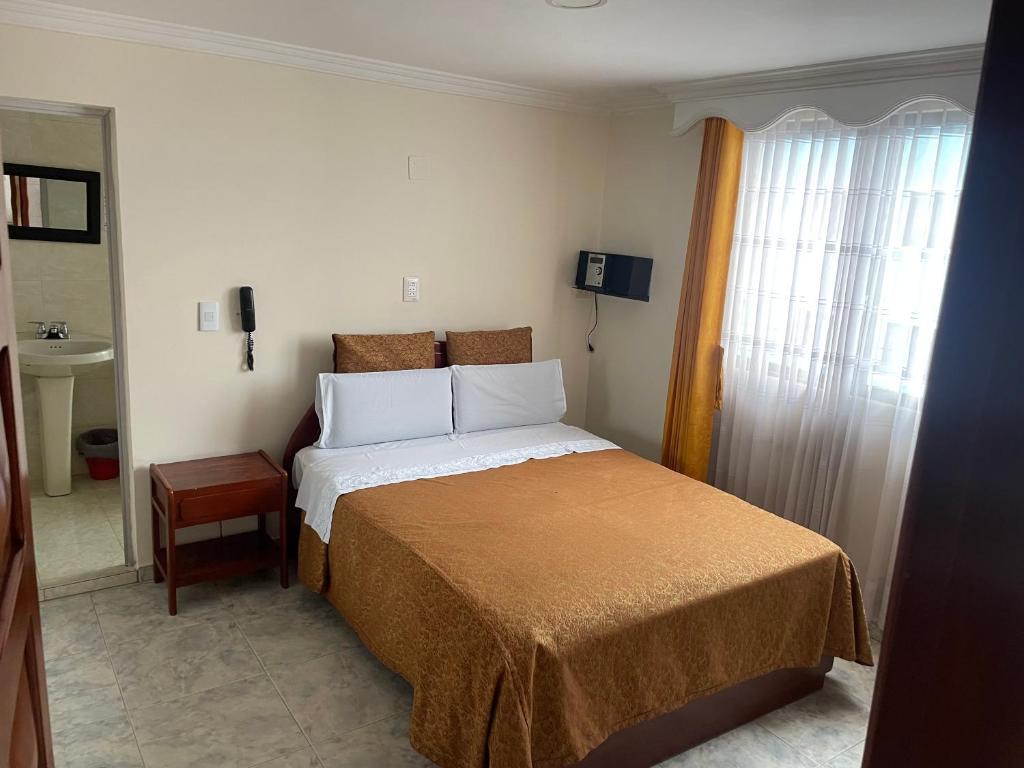 a bedroom with a bed and a window and a sink at Hotel Brisas Real in Bogotá