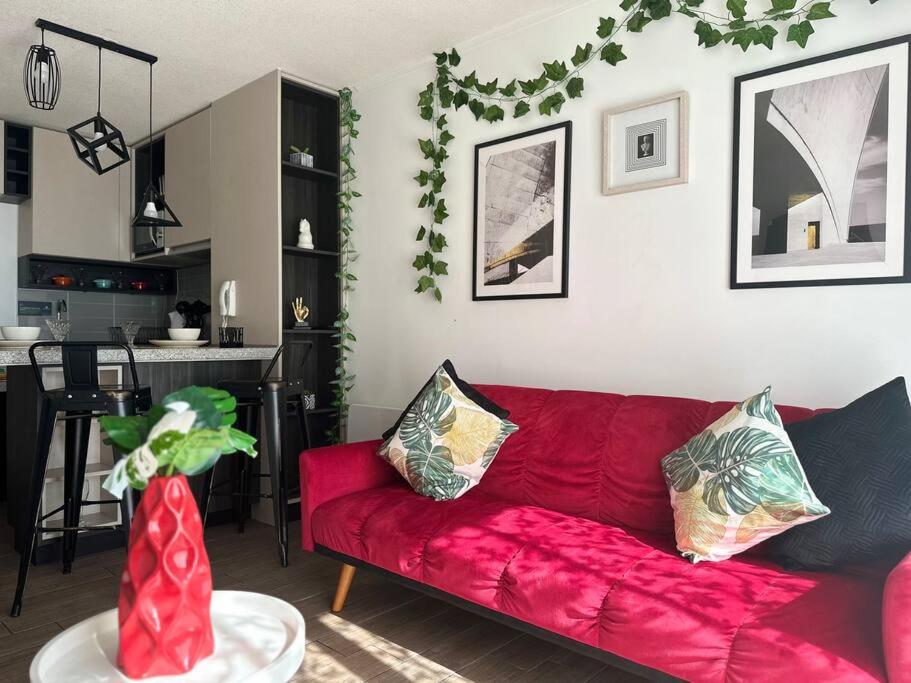 uma sala de estar com um sofá vermelho e uma cozinha em Depto full moderno Movistar Arena, Santiago de Chile em Santiago