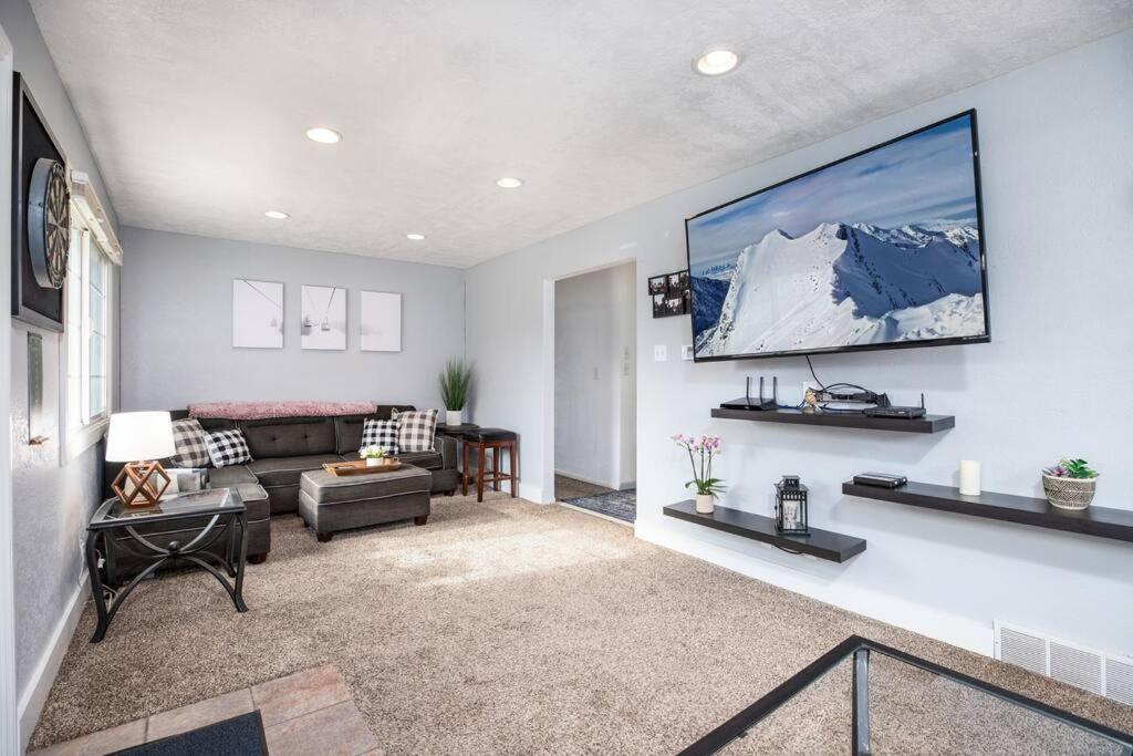 uma sala de estar com um sofá e uma televisão na parede em Pet Friendly Millcreek Home Close to Downtown/Mtns em Salt Lake City