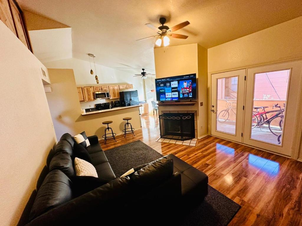 uma sala de estar com um sofá de couro e uma televisão em Cozy remodeled-condo near TUC Airport & Downtown em Tucson